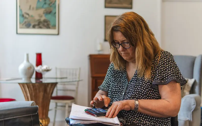 Homeowner checking figures with a calculator and notebook at home