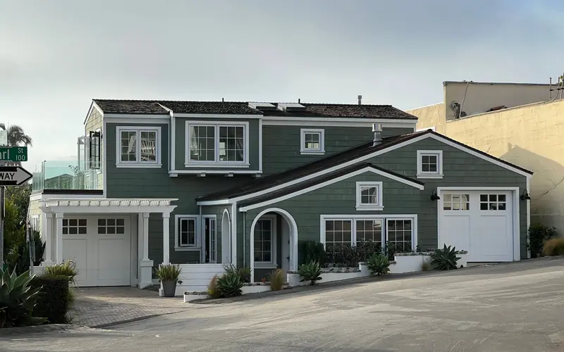 Two-story house with white trim, attached garage doors and a driveway